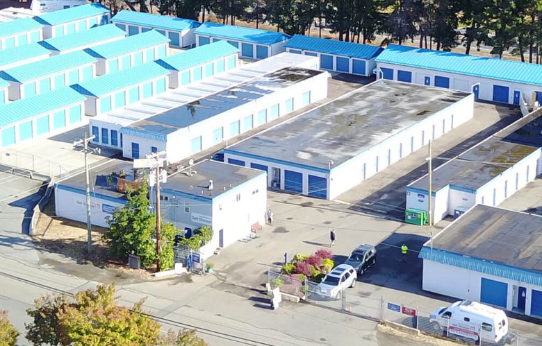 Front of PQ Self Storage building with gates and sign about first month free promo